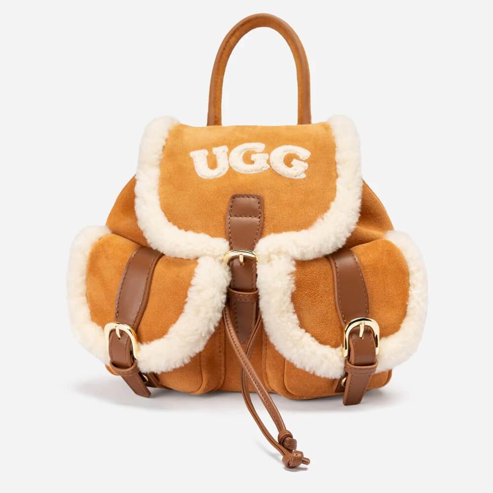 UGG Excursion 毛絨後背包正面照，羊皮與麂皮拼接，搭配雙口袋與金屬扣環