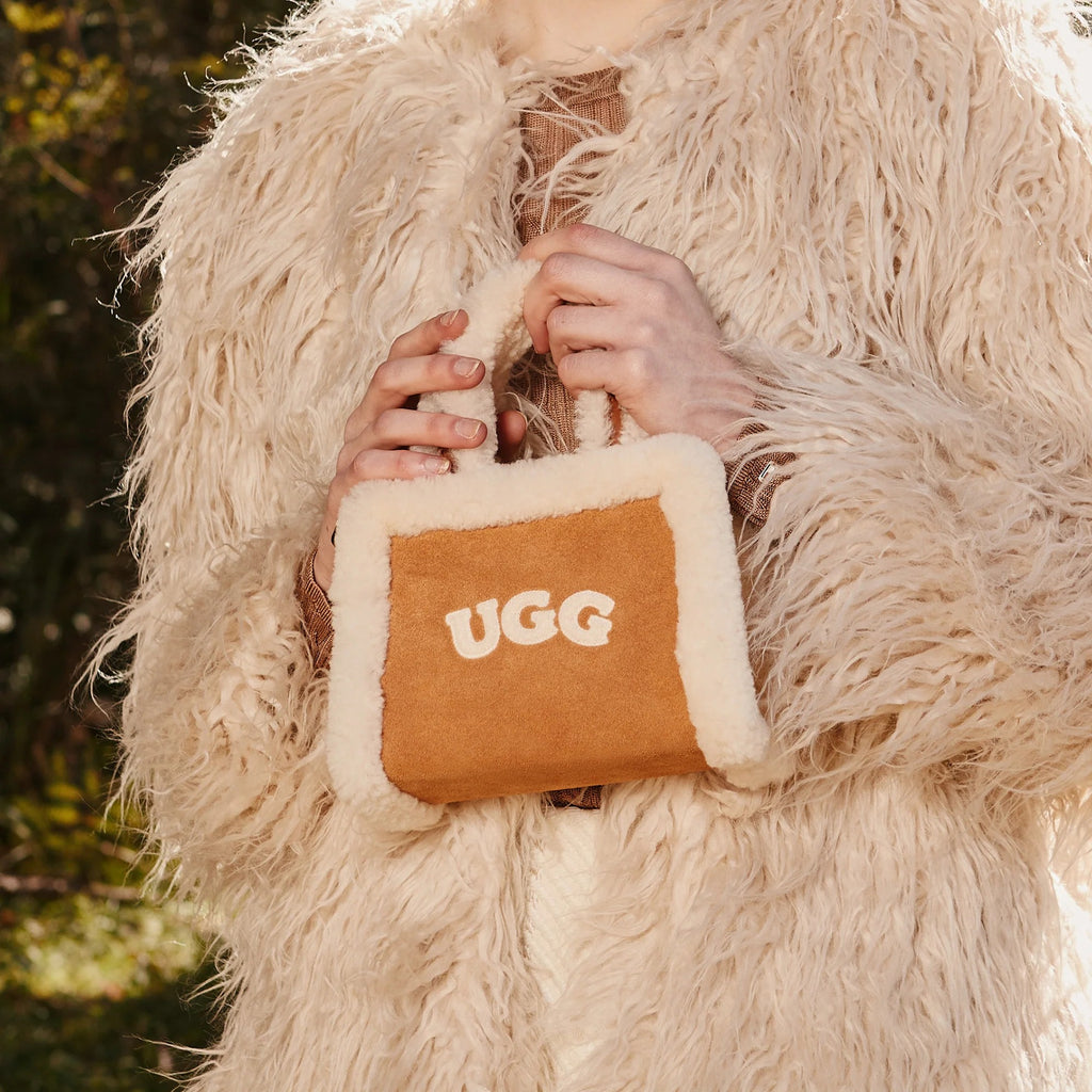 UGG 迷你托特包 穿搭情境圖，手拿羊羔毛提把，展示可愛的迷你尺寸。