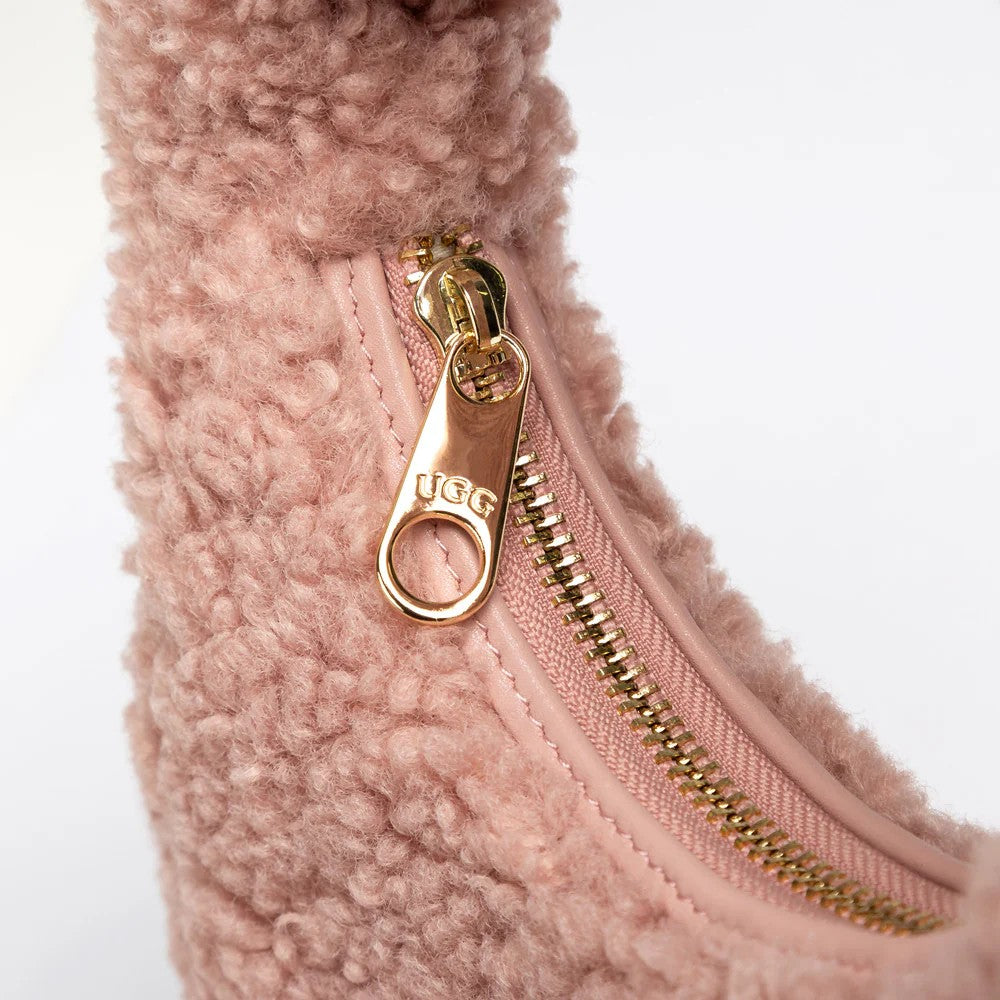 UGG Momo 灰粉色羊羔毛包 拉鍊特寫，可見金色五金拉鍊頭上刻有 UGG 標誌。