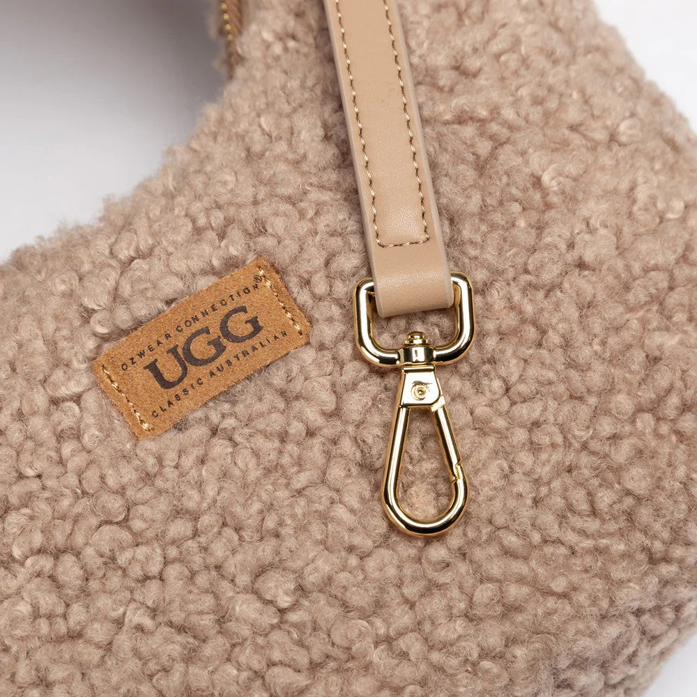 UGG Momo 奶茶棕包身 Logo 與扣環細節特寫，展示 UGG 皮革標籤與金色龍蝦扣。